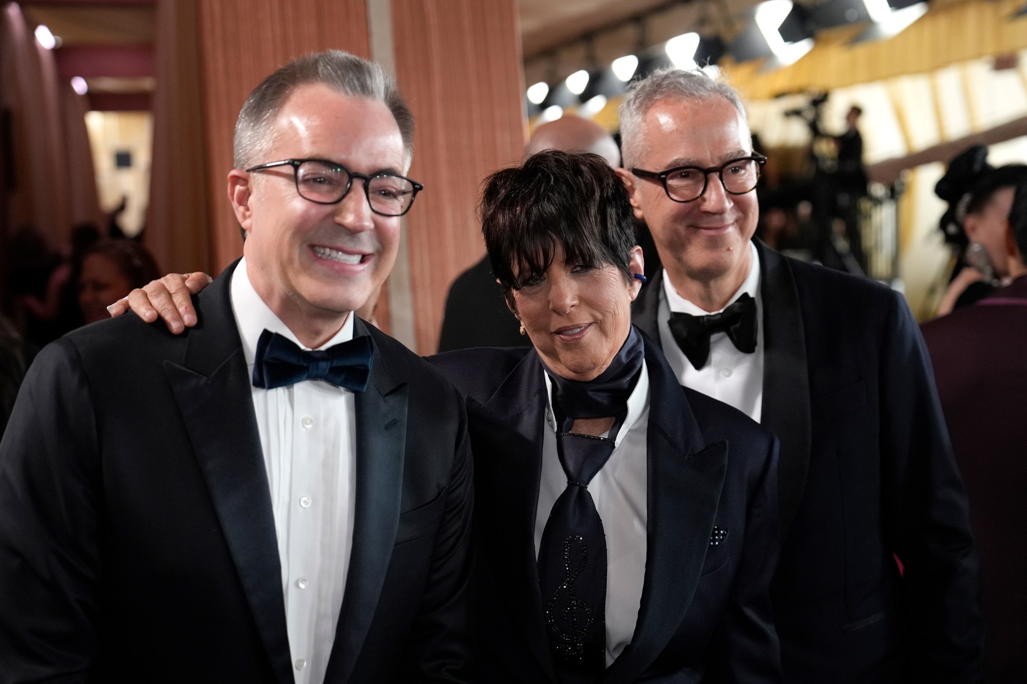 Chief Executive Officer of the Academy of Motion Picture Arts and Sciences, Bill Kramer, from left, Diane Warren and Peter Cipkowsk arrive at the Oscars on Sunday, March 2, 2025, at the Dolby Theatre in Los Angeles. (AP Photo/John Locher)