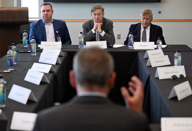 Senator John Hickenlooper, top-center, listens to Greg Ebel, Sc.D. Lab Principal Investigator Director, Center for Vector-Borne Infectious Diseases and Professor at CSU, during a round table discussion at CU Anschutz Cancer Center in Aurora on March 18, 2025. Seated next to Hickenlooper are Tom Gronow, Ed.D, president and chief executive officer of University of Colorado Hospital, on the left and Don Elliman, chancellor of the CU Anschutz Medical Campus, on the right. (Photo by Helen H. Richardson/The Denver Post)