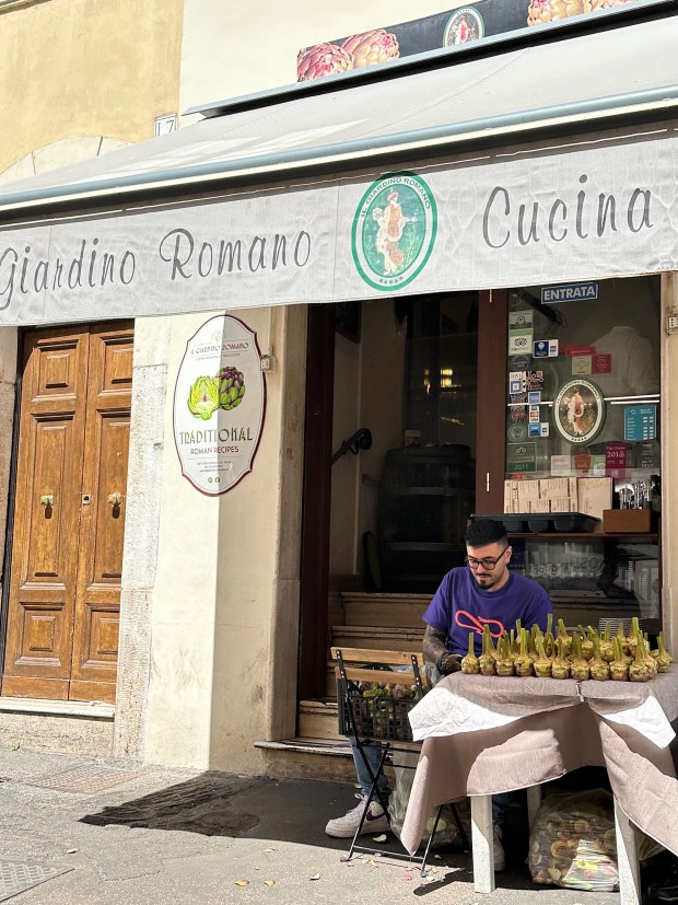 A man cleans artichokes in Rome. (Daliah Singer/Special to The Denver Post)