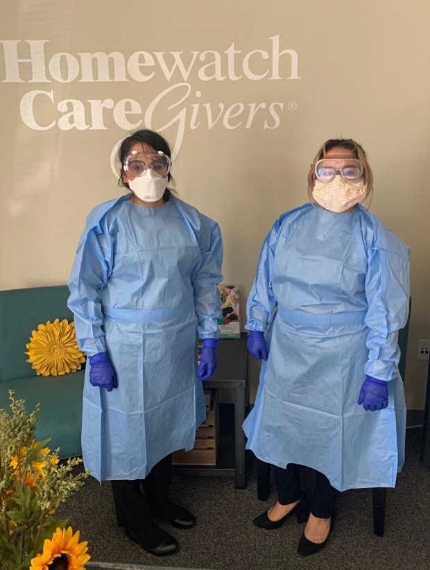 Two caregivers for Homewatch Caregivers in their personal protective equipment, ready to provide care.