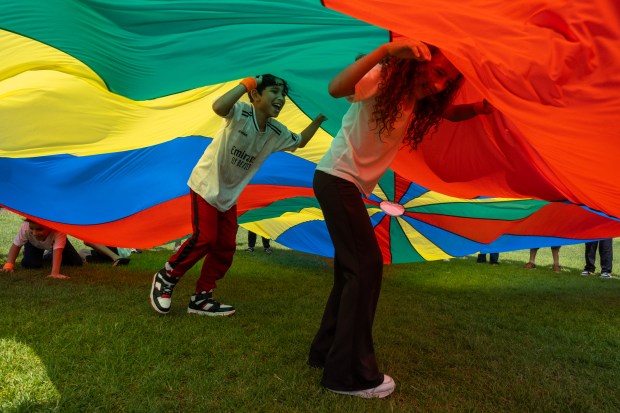 Children laugh together under a parachute during Field Day at Ashley Elementary School in Denver., on Friday, May 30, 2025. (Eli Imadali/Special to The Denver Post)