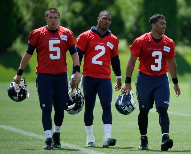 Seattle Seahawks quarterback Russell Wilson (3) walks off the field with backups Trevone Boykin (2) and Jake Heaps (5) following NFL football practice, June 2, 2017, in Renton, Wash. (AP Photo/Ted S. Warren)