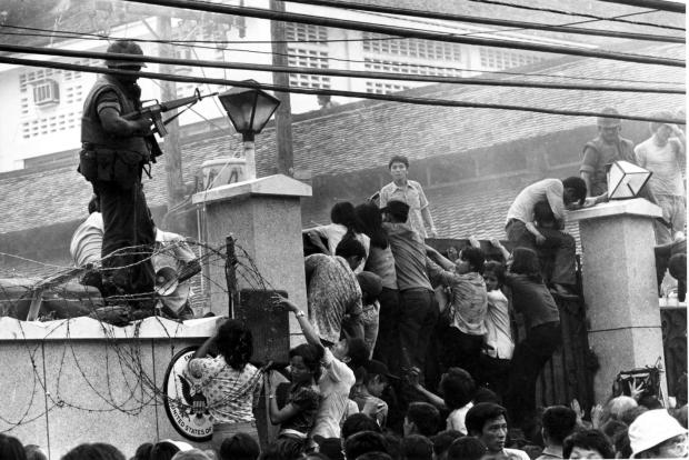 In this April 29, 1975 file photo, mobs of Vietnamese people scale the wall of the U.S. Embassy in Saigon, Vietnam, trying to get to the helicopter pickup zone, just before the end of the Vietnam War. (AP Photo/Neal Ulevich, file)