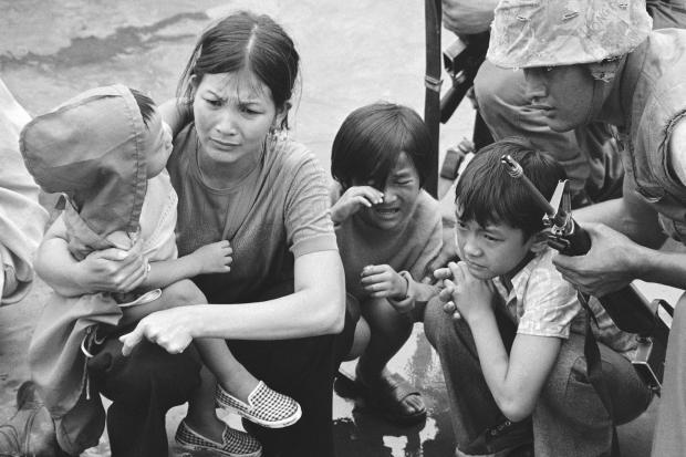 FILE- A weeping South Vietnamese mother and her three children are shown on the deck of this amphibious command ship being plucked out of Saigon by U.S. Marine helicopters in Vietnam, April 29, 1975. (AP Photo/J.T. Wolkerstorfer, File)