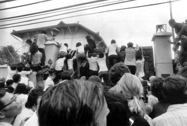 FILE - In this April 30, 1975 file photo, South Vietnamese civilians try to scale the walls of the U.S. embassy in Saigon in an attempt to get aboard evacuation flights. (AP Photo/Neal Ulevich, File)